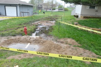 Caution tape defines the areas where diesel fuel overflowed from an underground tank and flowed into a residential neighborhood in McLouth Friday night. Photo by Clarke Davis