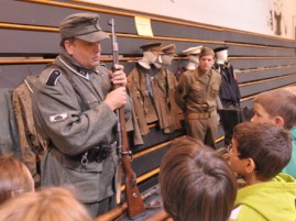 Ed Patterson (top left), Valley Falls, and Dylan Callahan, Emporia, provided a display of World War II uniforms and weapons for students to view during History Day at Valley Falls schools.